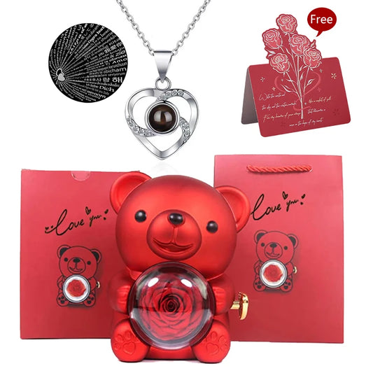 Elegancki czerwony miś trzymający wieczną różę w środku, obok czerwona torebka prezentowa z napisem Love you naszyjnik, wisiorek.